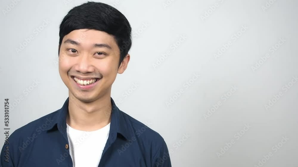 Cheerful asian man looking at side feels amazed smiling gesture close his eye Cheerful asian man looking at side feels amazed smiling gesture close his eye