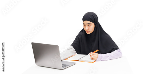 A Muslim girl uses a laptop computer for online learning.