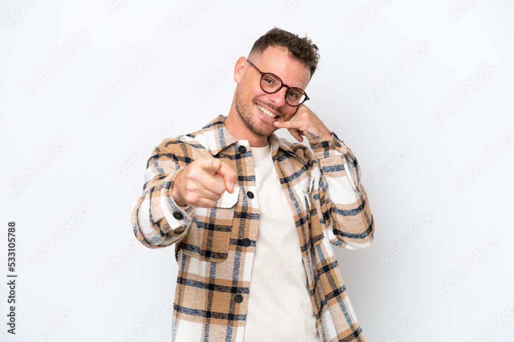 Young caucasian handsome man isolated on white background making phone gesture and pointing front Young caucasian handsome man isolated on white background making phone gesture and pointing front