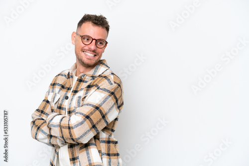 Young caucasian handsome man isolated on white background with arms crossed and happy