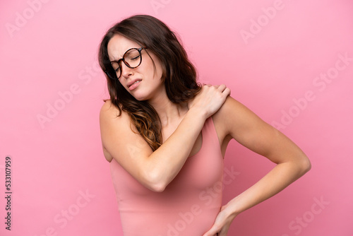 Young caucasian woman isolated on pink background suffering from pain in shoulder for having made an effort
