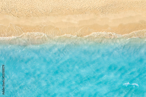 Fototapeta Naklejka Na Ścianę i Meble -  Summer seascape beautiful waves, blue sea water in sunny day. Top drone view. Sea aerial view, amazing tropical nature background. Beautiful bright sea waves surf on bright Mediterranean beach sand