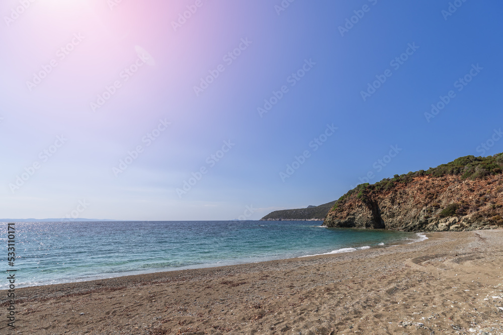 Meditative deserted sandy beach hidden from prying eyes somewhere on Sithonia cape at low tide and incandescent summer sun reaches its zenith, Toroni, Chalkidiki, Greece