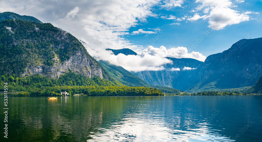 Hallstatt see lake near the Salzburg city. View of lake and big mountains in background. Cloudy weather, big clouds and mist over lake.