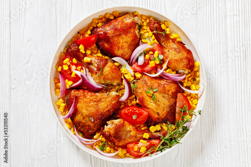 roast chicken with corn and tomatoes on plate