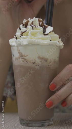 chocolate frappe or frapuccino with woman hand stirring iced. Vertical video photo