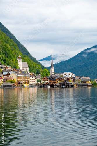 Hallstatt Village and Hallstatter See lake in Austria. Scenery with famous old church near the lake. Clouds and mist over the mountains in background. Famous tourist destination. © Martin