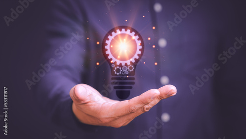 Man touching a bright light bulb icon. Ideas for presenting new ideas, inspiration in the work and innovation new beginning.