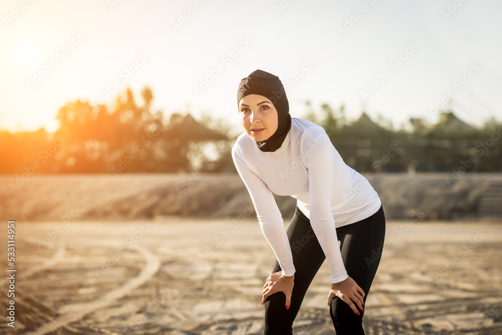 Arabian woman with typical muslim dress training outdoors in Dubai ...