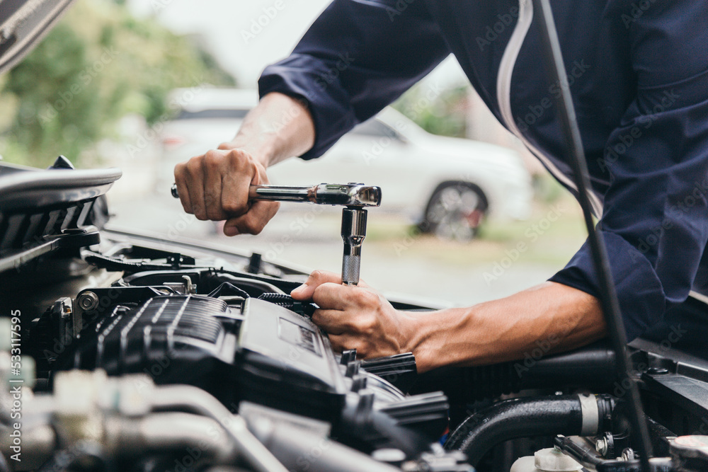 Automobile mechanic repairman hands repairing a car engine automotive workshop with a wrench, car service and maintenance,Repair service. Automobile mechanic repairman hands repairing a car engine automotive workshop with a wrench, car service and maintenance,Repair service.