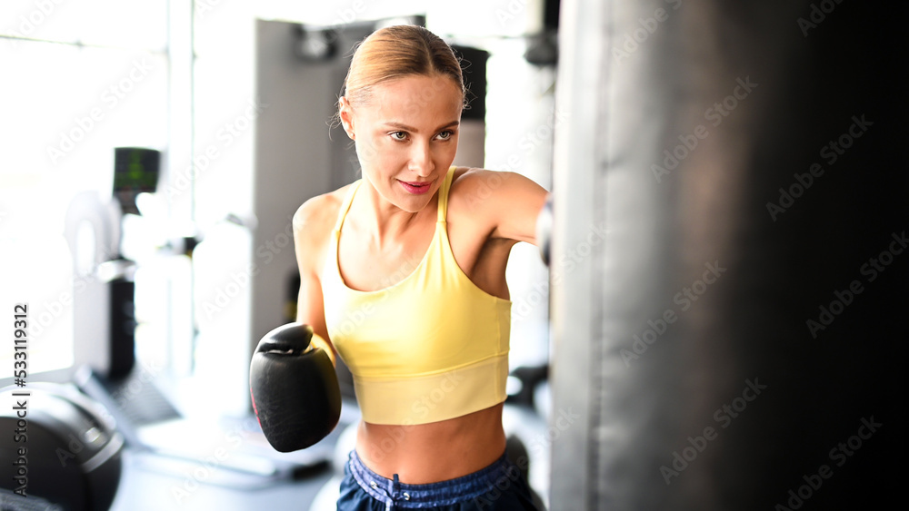 Beautiful young woman lifting dumbbells in a gym