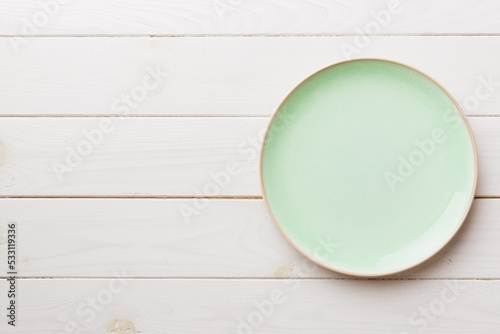 Top view of empty green plate on wooden background. Empty space for your design