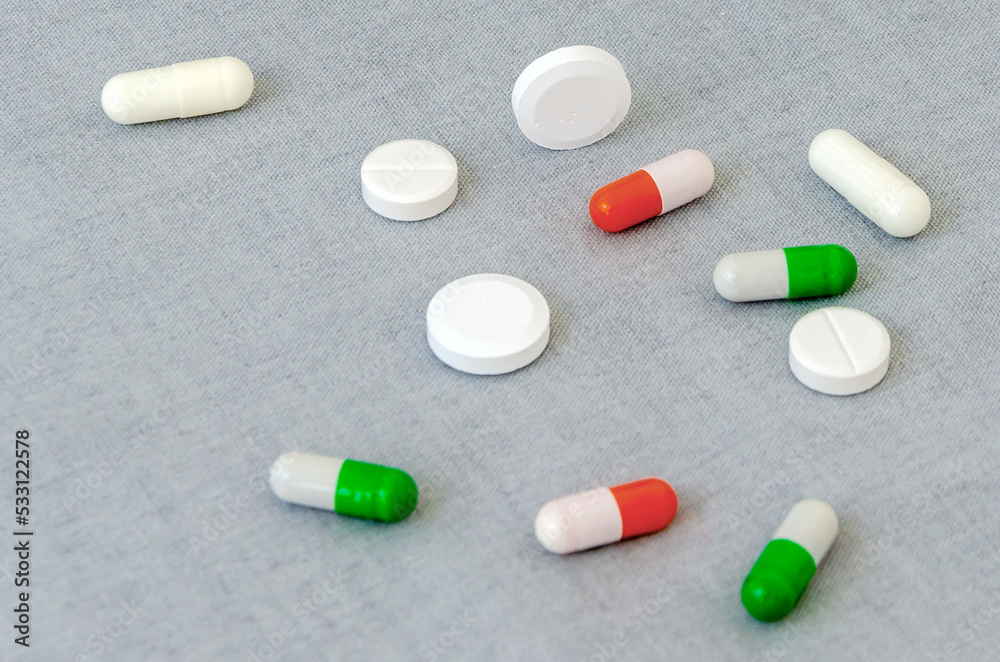 Medication: capsules and pills on a gray background. Medical concept. Close-up