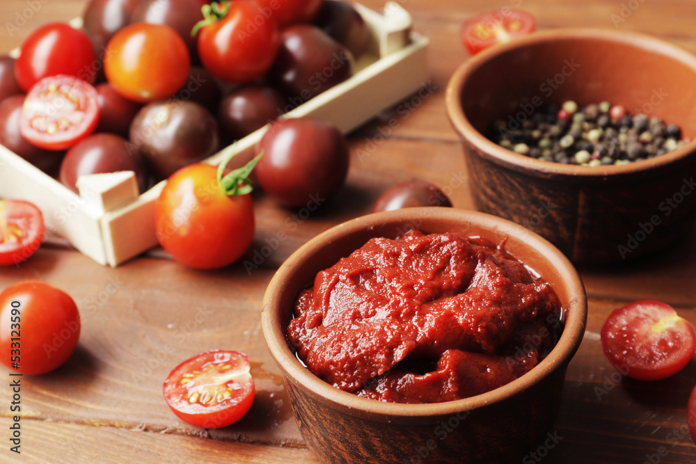Bowl full of tomato sauce, Wooden spoon full of tomato sauce, spices, seasonings, Procurement of ingredients for recipes. Bowl full of tomato sauce, Wooden spoon full of tomato sauce, spices, seasonings, Procurement of ingredients for recipes.