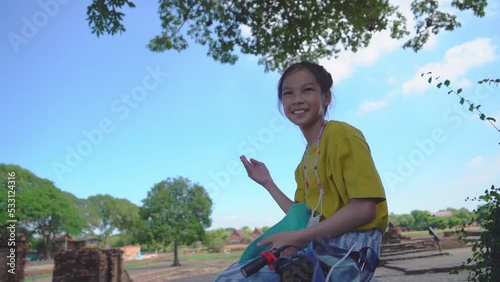 Girl sitting in Ayutthaya ruin while traveling in Thailand.