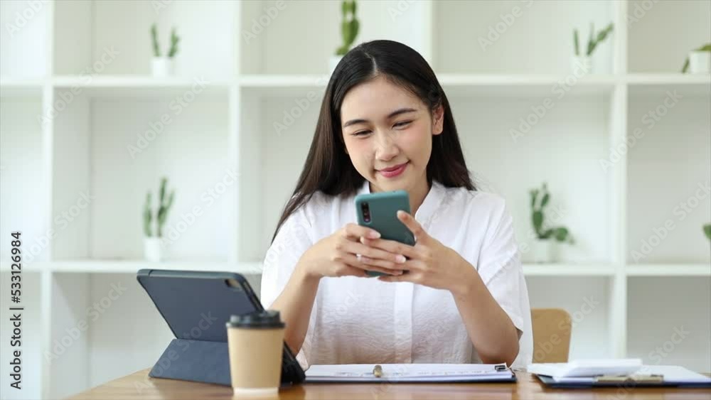 young businesswoman looking at financial information from a mobile phone, she is checking company financial documents, she is a female executive of a startup company. Concept of financial management. young businesswoman looking at financial information from a mobile phone, she is checking company financial documents, she is a female executive of a startup company. Concept of financial management.