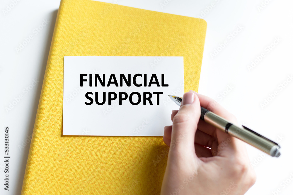 On the office table there is a notebook with the text FINANCIAL SUPPORT, Business concept