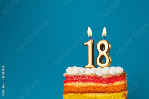Rainbow cake dessert with 18 number candles birthday concept.