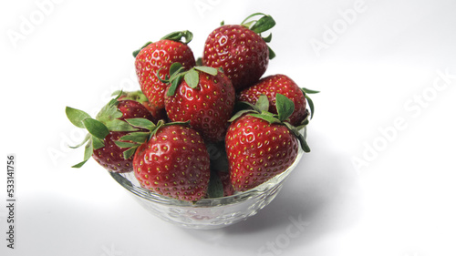Fresh strawberries in a transparent glass bowl