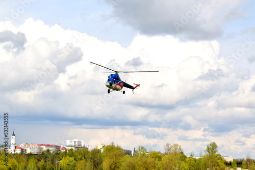 Fototapeta Naklejka Na Ścianę i Meble -  a small helicopter takes off from the field in the city