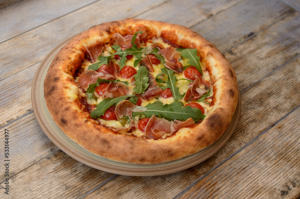 Very tasty pizza on a wooden background.