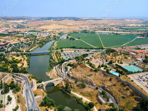 The Tagus River in Toledo with the Alcantara Bridge and the  Castle of San Servando on the right bank photo