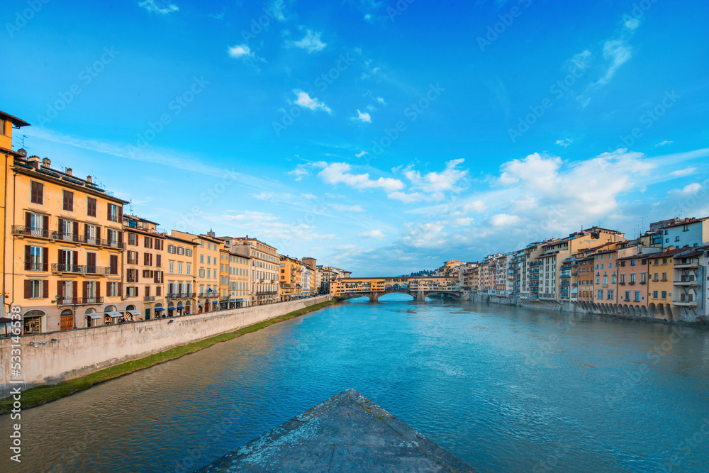 The Ponte Vecchio, Old Bridge, is a Medieval stone closed-spandrel segmental arch bridge over the Arno River, with shops built along it; as jewelers, art dealers and souvenir sellers. Italy, 2019