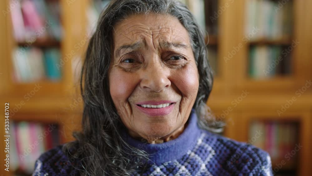 Portrait of senior woman in library with a smile on her face. Mexican, happy and old woman laughing, smiling and an expression of relief in retirement. Elderly librarian with books in the background Portrait of senior woman in library with a smile on her face. Mexican, happy and old woman laughing, smiling and an expression of relief in retirement. Elderly librarian with books in the background