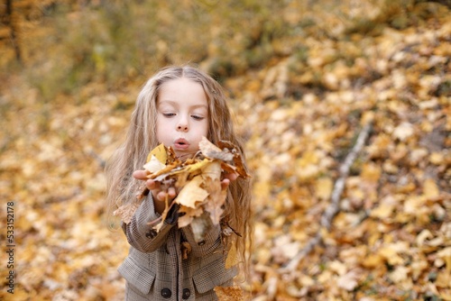 Portrait of a fashion little girl having fun in autumn forest