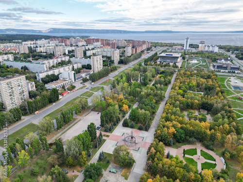 Panoramic view from the drone of a walking park near residential buildings. Urban landscape  bird s-eye view from the park. Cloudy weather over the city.