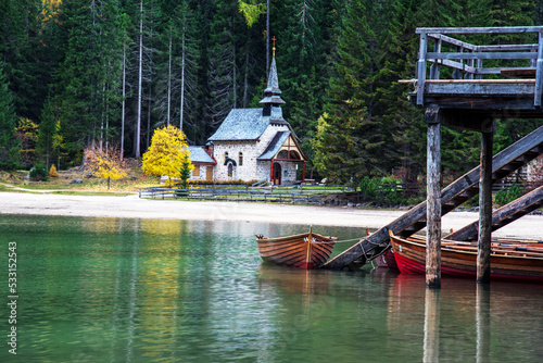 Obraz na płótnie charming fascinating autumn landscape with a church and boats on the lake on Fanes-Sennes-Braies natural park in the Dolomites in South Tyrol, Alps, Italy. w salonie