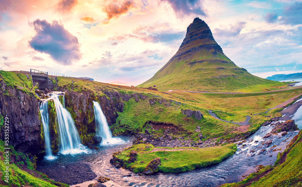 Beautiful natural magical scenery with a waterfall Kirkjufell near the volcano at dawn in Iceland. Exotic countries. Amazing places. Popular tourist atraction. (Meditation, antistress - concept).