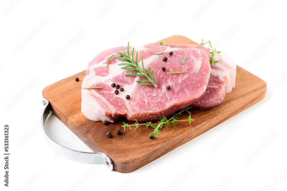 Pieces of pork meat with rosemary and thyme leaves on wood plate isolated on white
