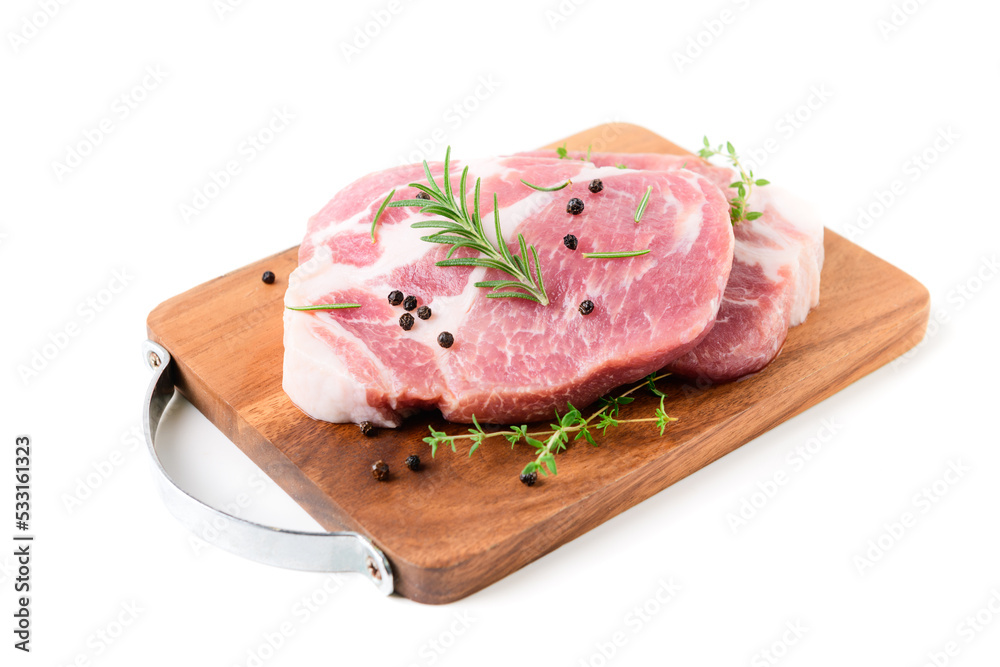 Pieces of pork meat with rosemary and thyme leaves on wood plate isolated on white Pieces of pork meat with rosemary and thyme leaves on wood plate isolated on white