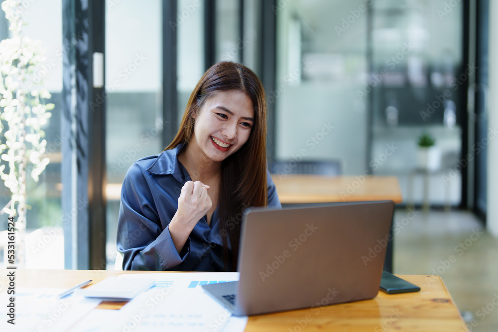 Portrait of an Asian female employee using computer with a smiling face as she works the next morning Portrait of an Asian female employee using computer with a smiling face as she works the next morning