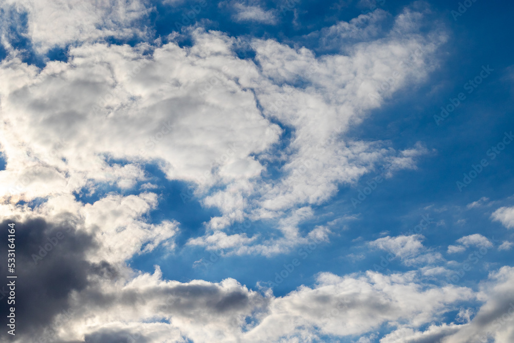 Einige Wolken in den Farben weiss bis grau vor strahlend blauem Hintergrund an einem sonnigen Sommertag Einige Wolken in den Farben weiss bis grau vor strahlend blauem Hintergrund an einem sonnigen Sommertag