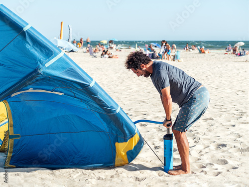 Man preparing kiteboarding kite before kitesurfing. Preparation before kiting.