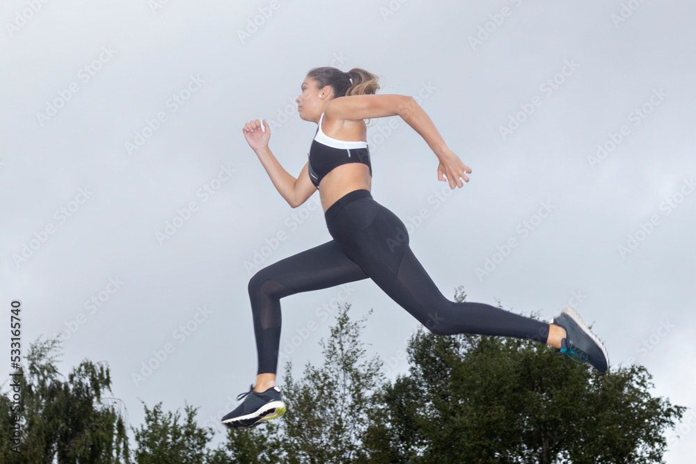 portrait of a sporty woman jumping in the air in sportswear outdoors. Sports lifestyle concept portrait of a sporty woman jumping in the air in sportswear outdoors. Sports lifestyle concept