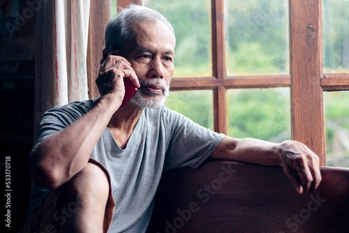 bearded senior man talking by phone