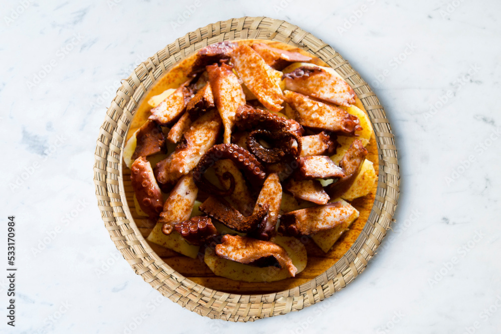 Galician-style octopus or feira-style octopus. Tapa recipe typical of the north of Spain from the region of Galicia. Octopus cooked with paprika and potato. Galician-style octopus or feira-style octopus. Tapa recipe typical of the north of Spain from the region of Galicia. Octopus cooked with paprika and potato.