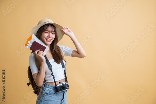 young attractive Asian woman traveler in casual clothes wearing straw hat with backpack, passport, camera and boarding pass ticket, Tourist girl having cheerful holiday trip concept