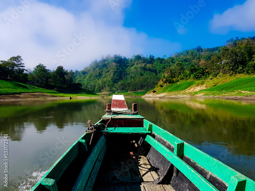 Traditional boat ride with the hills and clouds around on the Shangu river in Bangladesh in winter