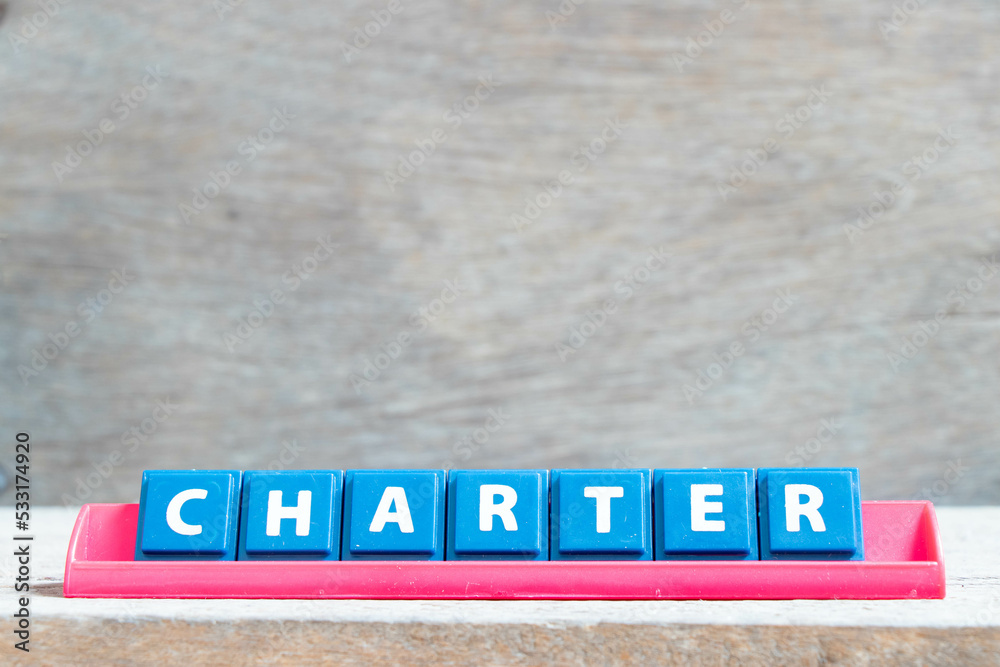 Tile alphabet letter with word charter in red color rack on wood background