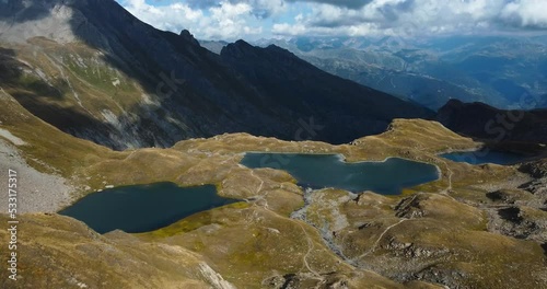 4K drone shot on top of a mountain with a vibrant background view of Forclaz lakes in the french Alps photo