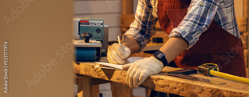 Carpenter man working use pencil sketching design woodwork furniture in carpentry workshop. Craftsman and DIY handmade. photo