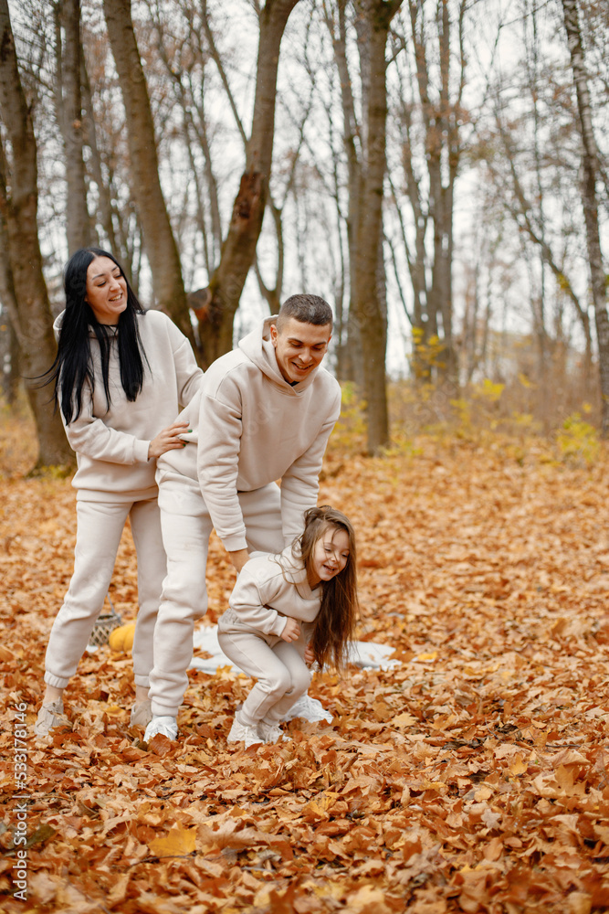 Young family playing in autumn forest and hugging Young family playing in autumn forest and hugging