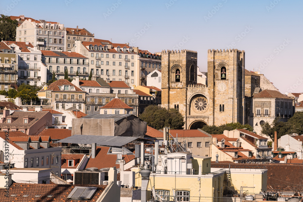 Lisbon, capital city of Portugal. Cityscape with Lisbon Cathedral, the Sé de Lisboa. Rooftop view over historic downtown Lisbon at golden hour sunset.