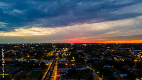 beautiful aerial drone shot of Chicago during a sunset in an urban neighborhood. sky is full of wonderful colors as the street lights glow across the city 