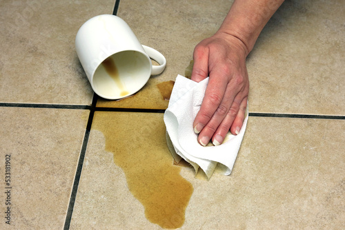 cleaning up a coffee spillage using a paper towel