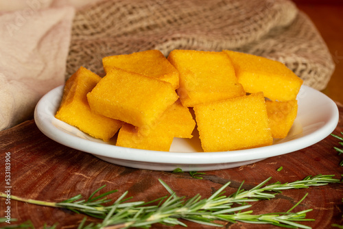 Portion of fried polenta . Polenta cubes.Typical Italian fried polenta. Fried corn sticks.